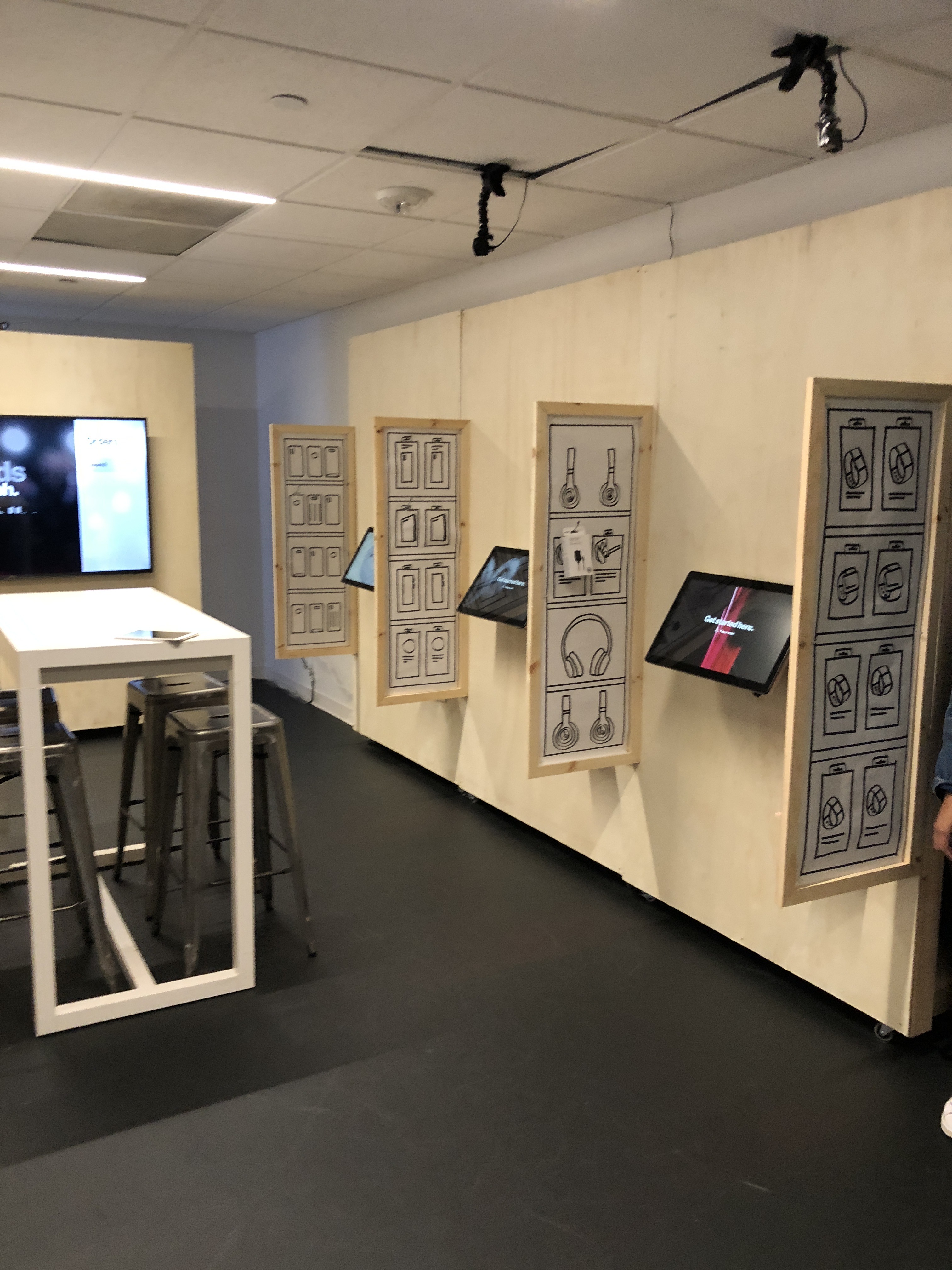 A conference room converted into a full-scale Express Store prototype, with paper mockups and demo kiosks