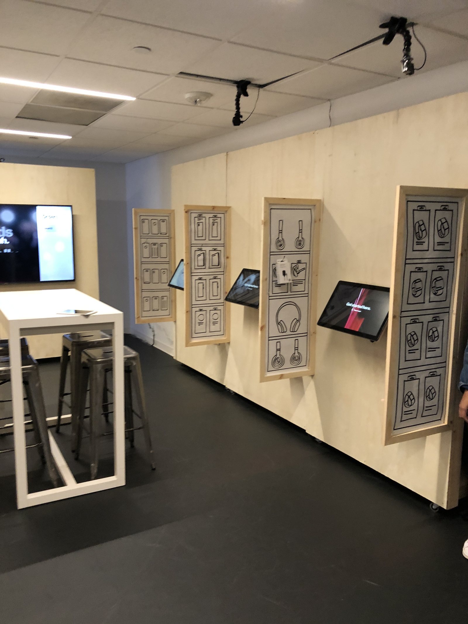 A conference room converted into a full-scale Express store prototype, with paper mockups and demo kiosks