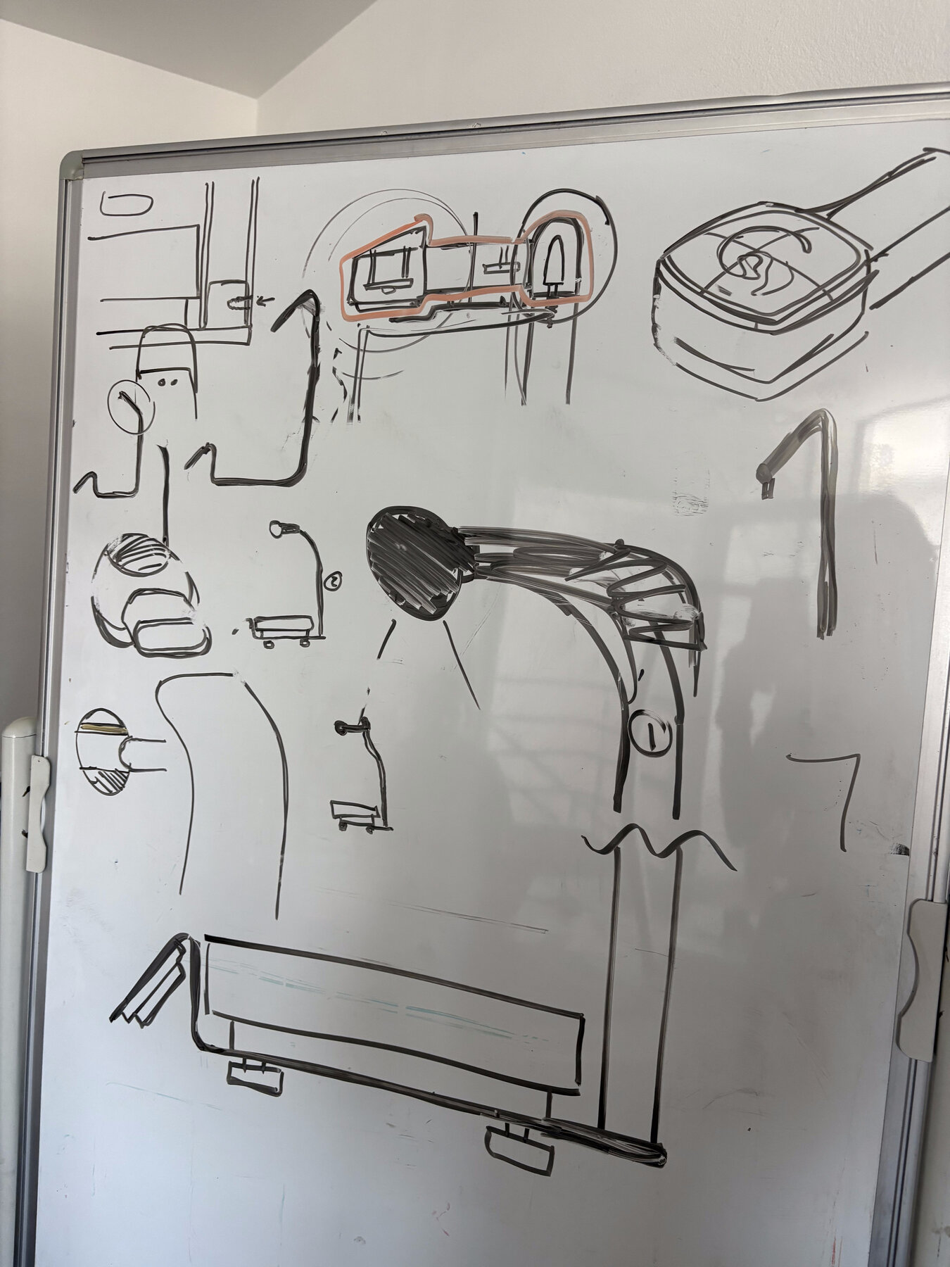 A whiteboard covered in industrial design sketches exploring the scale's enclosure, camera arm mount, and hinge details
